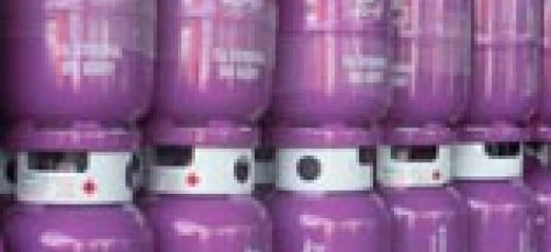 Zblilony na zdjęciu zbiornik magazynowy w kształcie cylindra wykonany z tworzywa sztucznego i stali, używany jako zbiornik paliwa w maszynie.