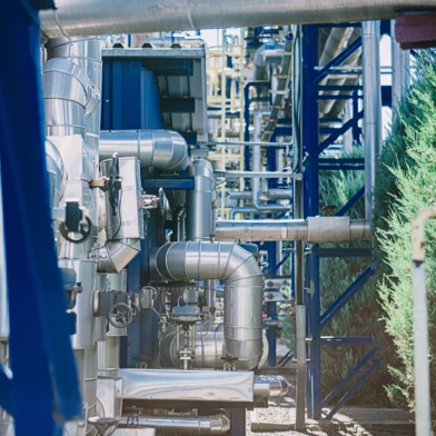 A pipeline in a factory made of composite material being inspected by engineers. Industry machinery in a metal pumping station.